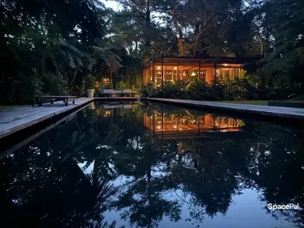 Casa de cristal junto a la pileta al atardecer