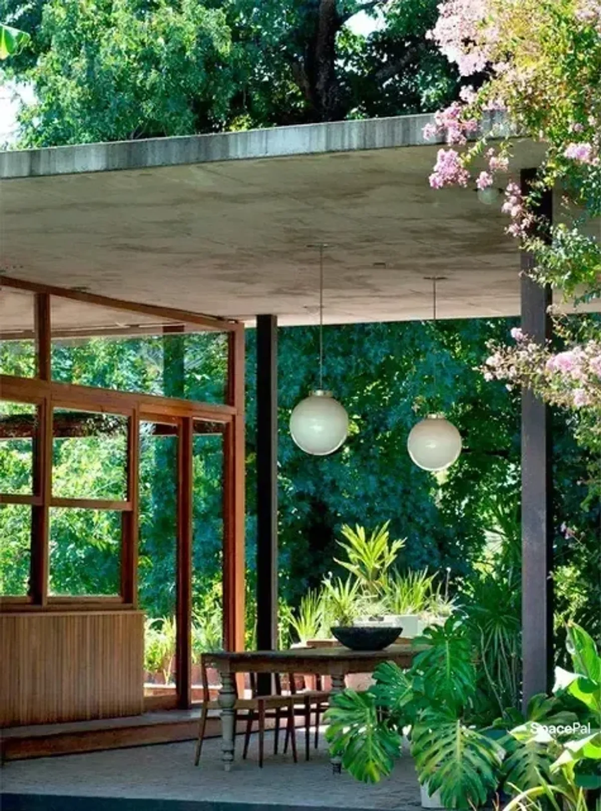 Galería de hormigón y madera con vegetación