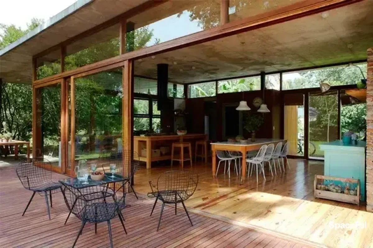 Deck y comedor abierto rodeado de naturaleza